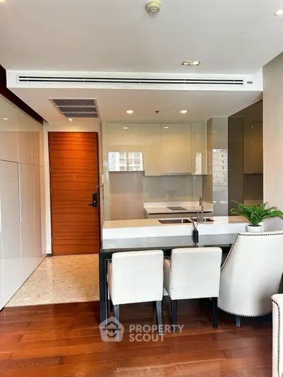 Modern kitchen with sleek design, open layout, and stylish dining area in luxury apartment.