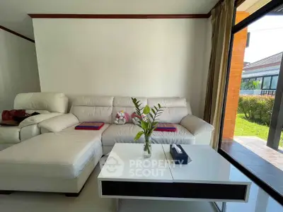 Spacious living room with modern white sofa and garden view, perfect for relaxation and entertaining.