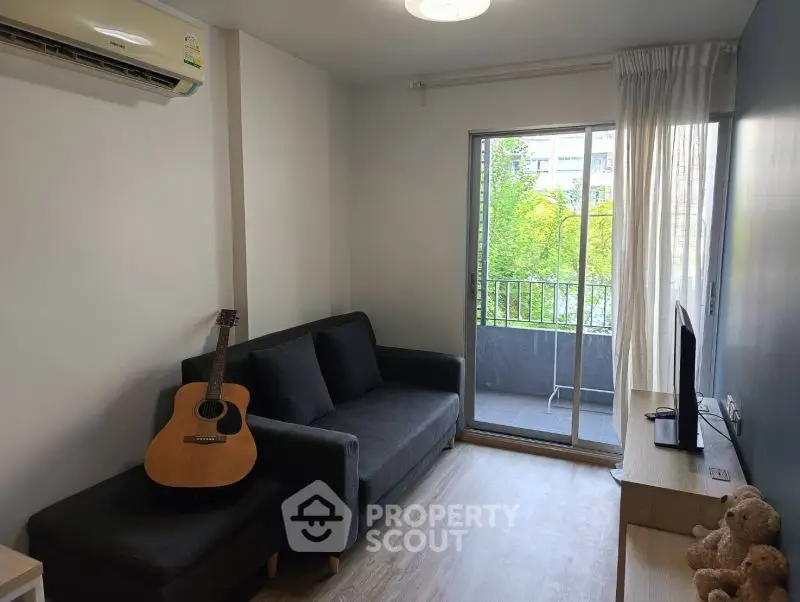 Cozy living room with sofa, guitar, and balcony view in modern apartment
