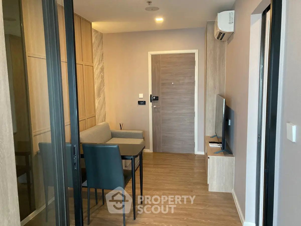 Modern living room with sleek furniture and wooden flooring in a stylish apartment.