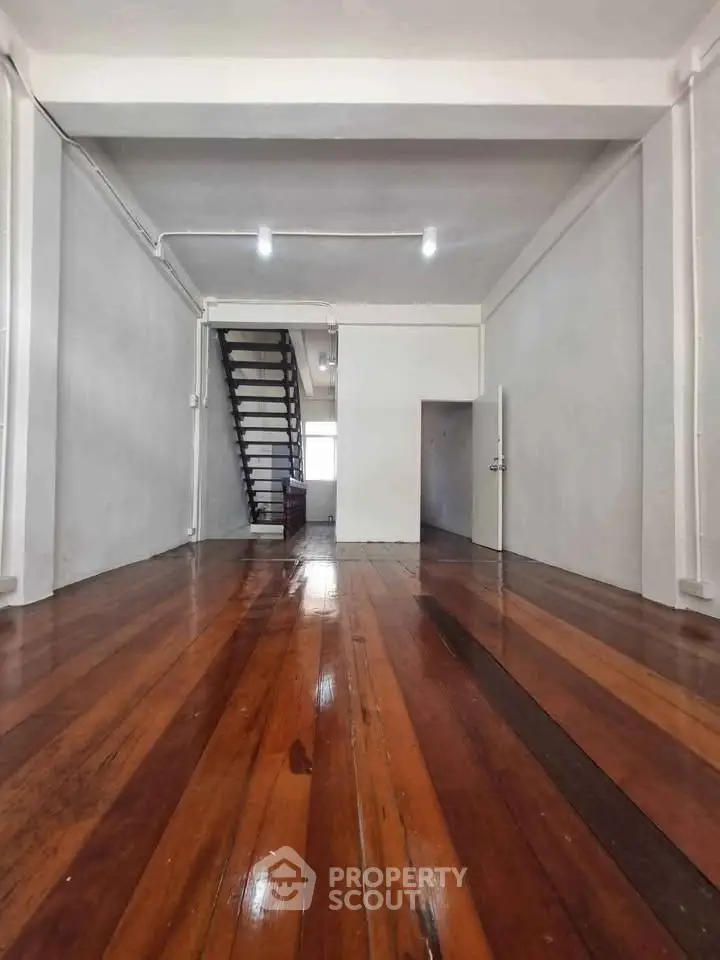 Spacious interior with polished wooden floors and staircase, ideal for modern living.