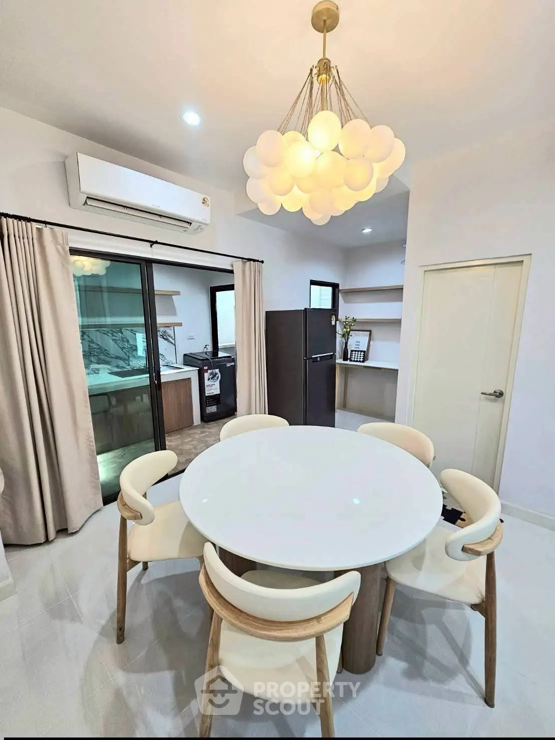 Modern dining area with round table and stylish lighting in open-plan apartment