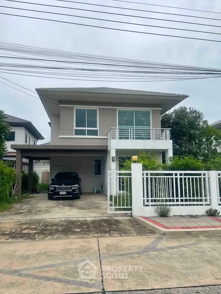Modern two-story house with carport and gated entrance in suburban neighborhood.