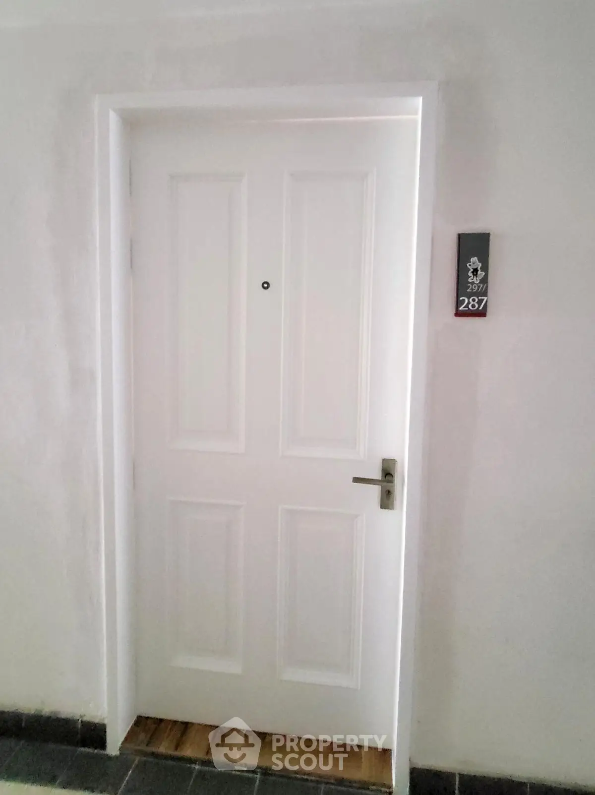 Modern apartment entrance with sleek white door and room number 287, ideal for urban living.