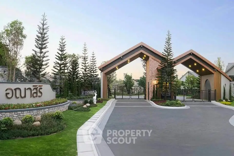 Elegant gated entrance of a modern residential community with lush landscaping.