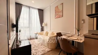 Modern living room with elegant decor and dining area, featuring large window and cozy seating.