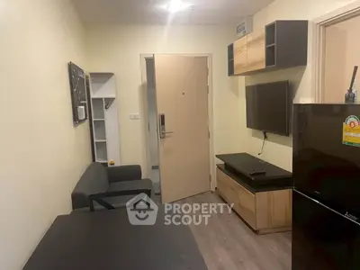 Modern living room with sleek furniture and wall-mounted TV in a cozy apartment.