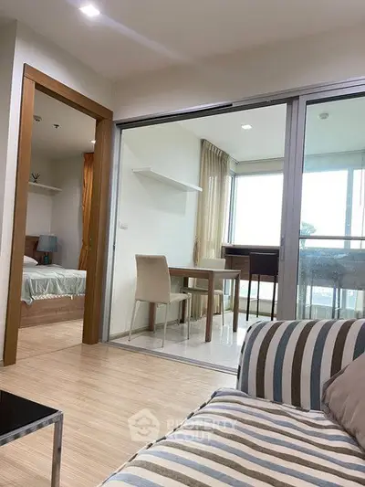 Modern apartment interior with open living room and dining area, featuring stylish furniture and natural light.