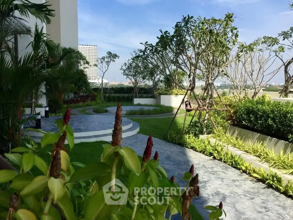 Lush garden with paved pathways and vibrant greenery in modern residential complex.