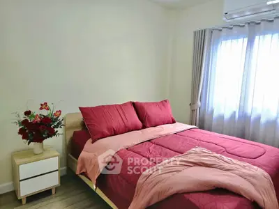 Cozy bedroom with red bedding and natural light, perfect for relaxation.
