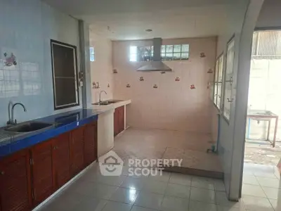 Spacious kitchen with dual sinks and tiled backsplash, perfect for culinary enthusiasts.