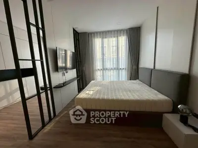 Modern bedroom with sleek design, featuring a large bed, wall-mounted TV, and stylish partition.