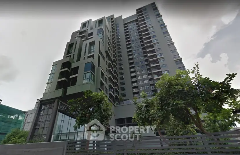 Modern high-rise building exterior with lush greenery and contemporary design.