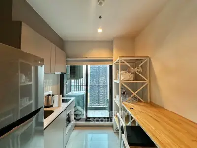 Modern kitchen with sleek appliances and balcony view in urban apartment