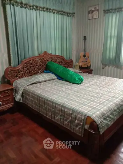 Charming bedroom with ornate wooden bed and cozy decor, perfect for relaxation.