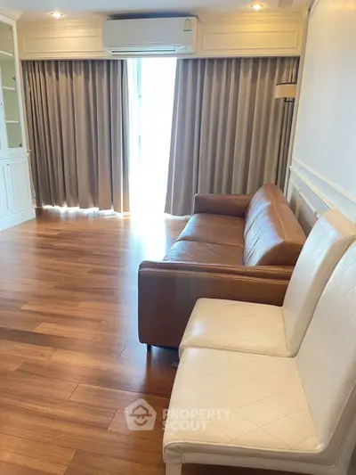 Spacious living room with elegant wooden flooring and stylish furniture