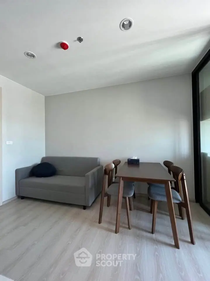 Modern minimalist living room with gray sofa and wooden dining set