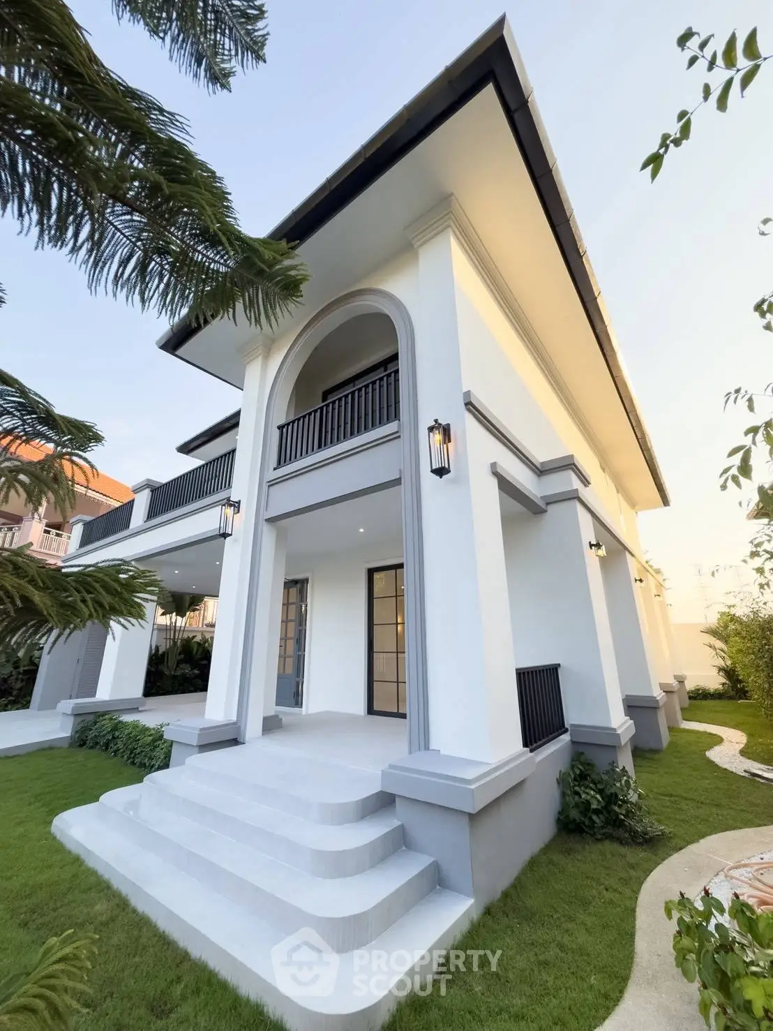 Elegant modern villa with lush garden and grand entrance, perfect for luxury living.