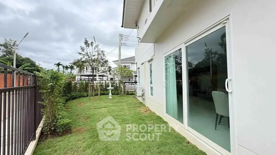 Charming backyard with lush green lawn and modern sliding glass doors in suburban home.