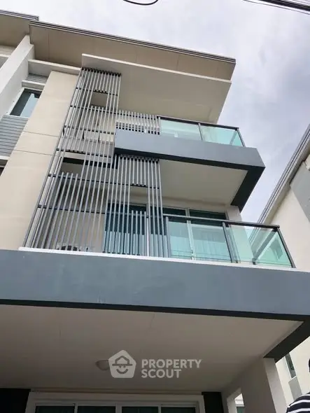 Modern multi-story building with sleek balconies and contemporary design.