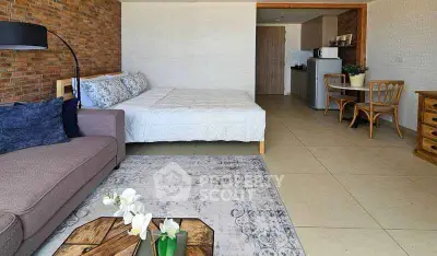 Spacious studio apartment with modern decor and open layout, featuring cozy seating and dining area.