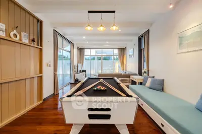 Spacious living room with pool table and modern decor, perfect for entertainment and relaxation.