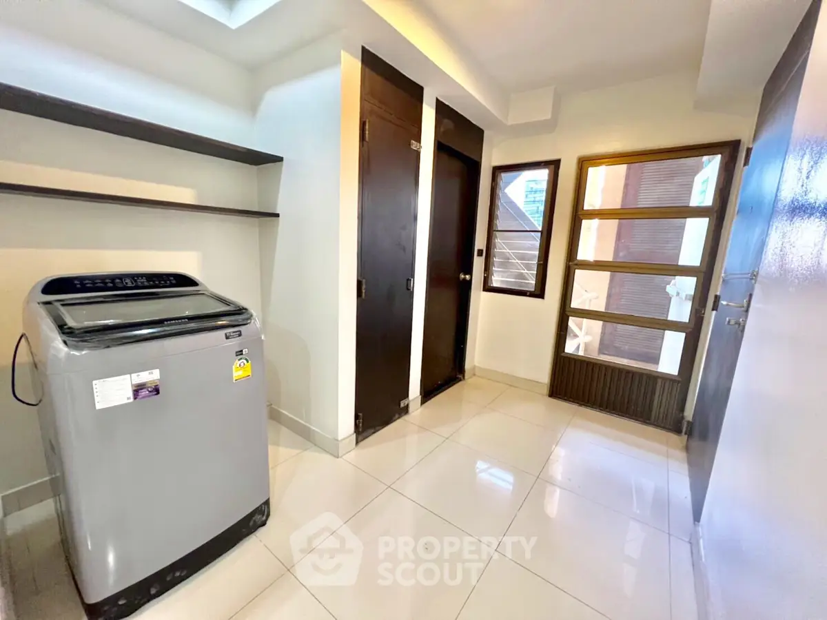 Spacious laundry room with modern washing machine and ample storage space.