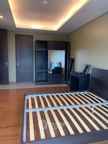 Spacious bedroom with modern wooden flooring and built-in wardrobe