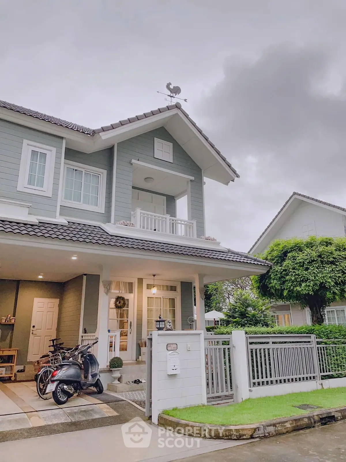 Charming two-story house with modern design and lush greenery, perfect for family living.