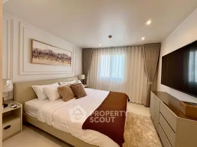 Luxurious bedroom with elegant decor and large TV, perfect for relaxation.