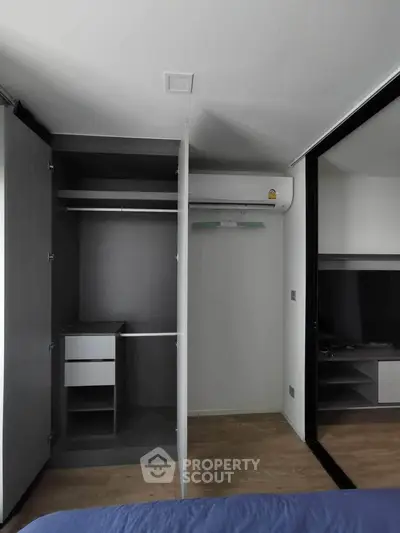 Modern bedroom with open wardrobe and air conditioning unit