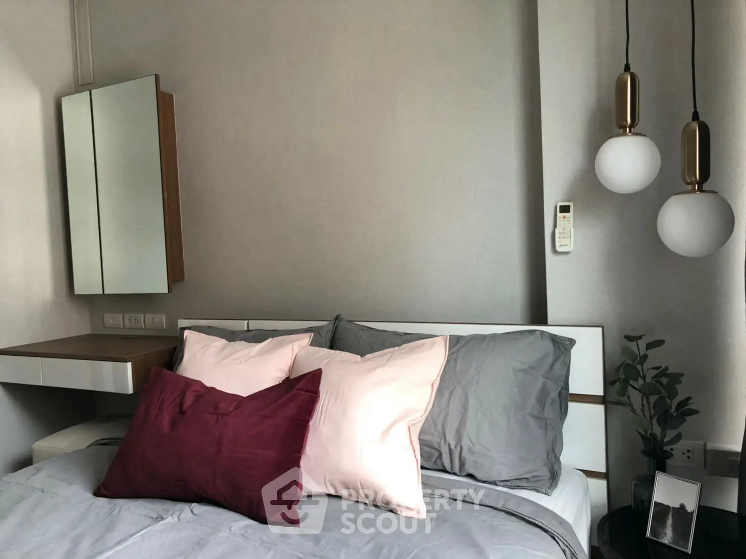 Modern bedroom with stylish pendant lights and cozy bedding