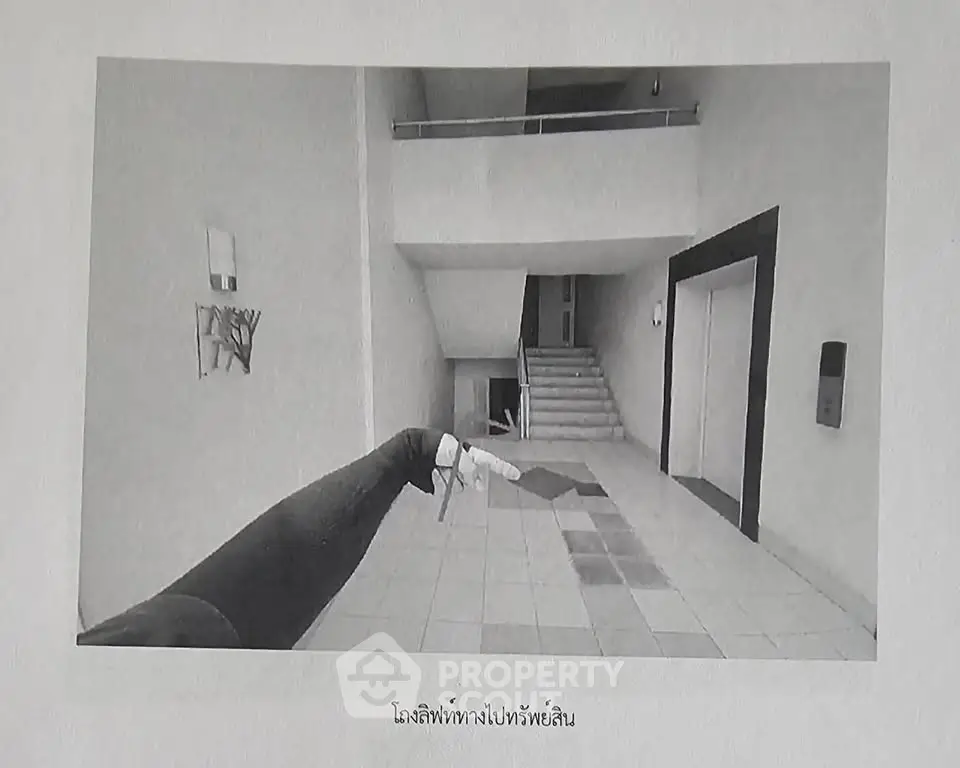 Spacious building entrance with modern design and tiled flooring.