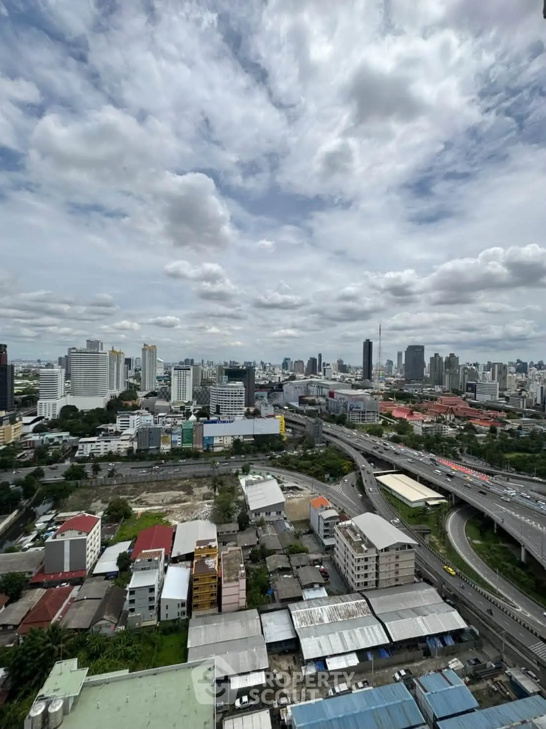 Stunning cityscape view from high-rise building showcasing urban skyline and highway.