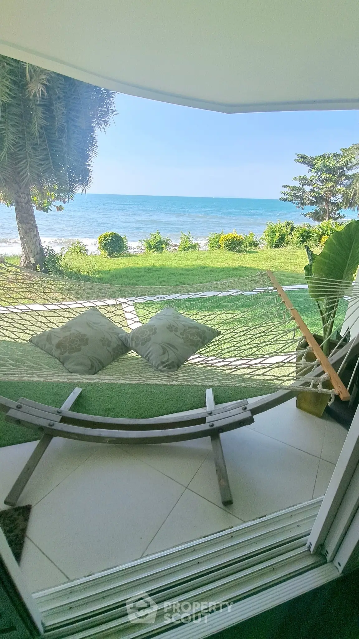 Stunning beachfront view with hammock and lush greenery for ultimate relaxation.