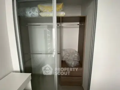 Spacious modern closet with sliding glass doors and wooden shelves.