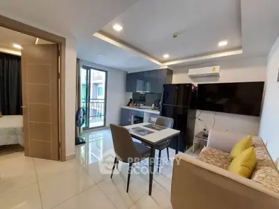 Modern open-plan living room with sleek kitchen and dining area, featuring contemporary furniture and stylish decor.