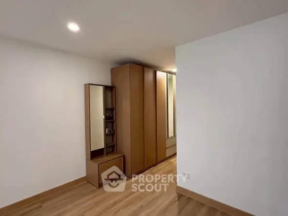 Spacious bedroom with modern wooden wardrobe and sleek flooring
