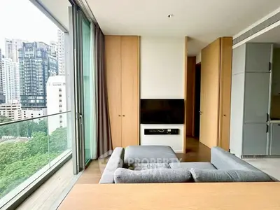 Modern living room with city view and sleek furniture in high-rise apartment.