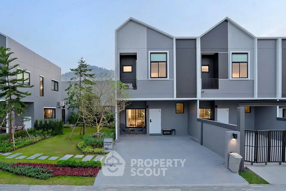 Modern townhouse exterior with landscaped garden and driveway in serene neighborhood.