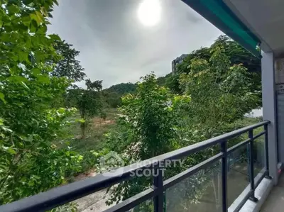 Scenic balcony view with lush greenery and distant hills, perfect for nature lovers.