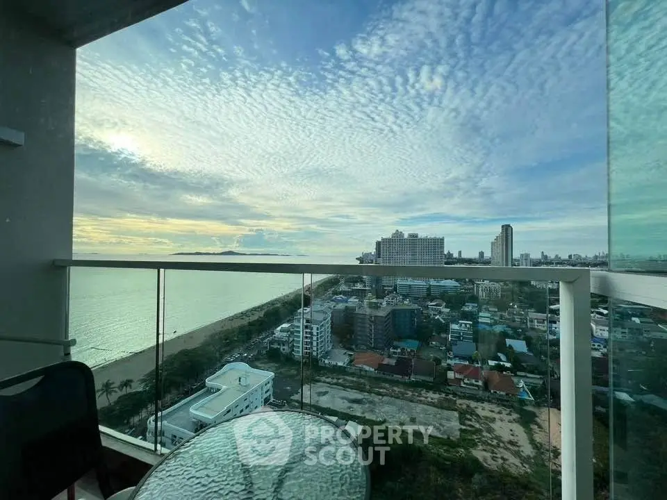 Stunning high-rise balcony view overlooking cityscape and ocean, perfect for urban living.