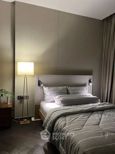 Elegant bedroom with modern decor and cozy lighting, featuring a stylish bed and floor lamp.