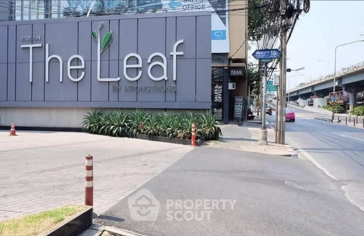 Modern building exterior with The Leaf signage and urban street view.