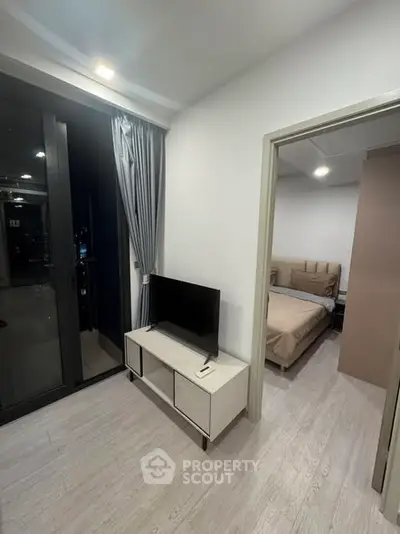 Modern apartment interior with cozy bedroom and sleek living area, featuring stylish decor and natural lighting.