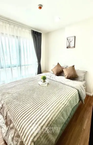 Cozy bedroom with large window and stylish decor in modern apartment