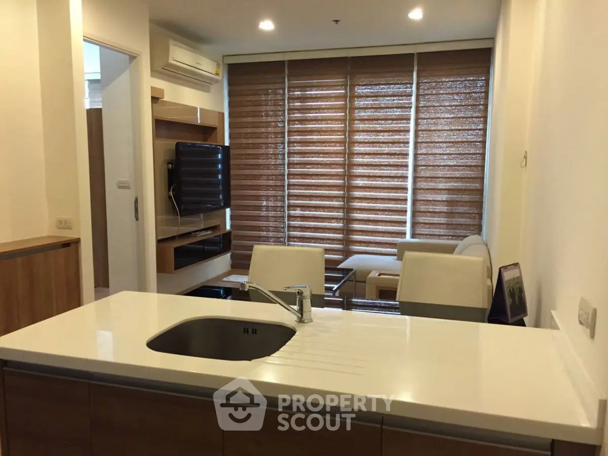 Modern open-layout living room with kitchen island and stylish blinds