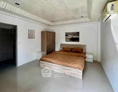 Spacious bedroom with modern decor and air conditioning in a stylish home.