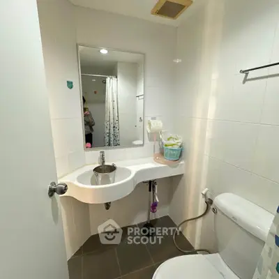Modern bathroom with sleek fixtures and white tiles, featuring a compact design and contemporary style.