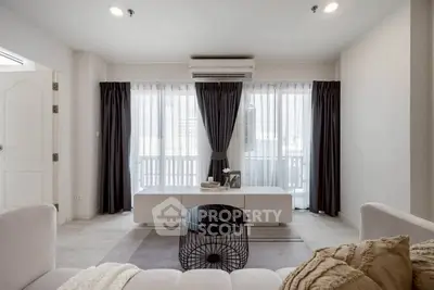 Modern living room with stylish decor and large windows offering natural light.